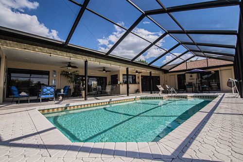 A screened lanai pool alongside a Lee County home